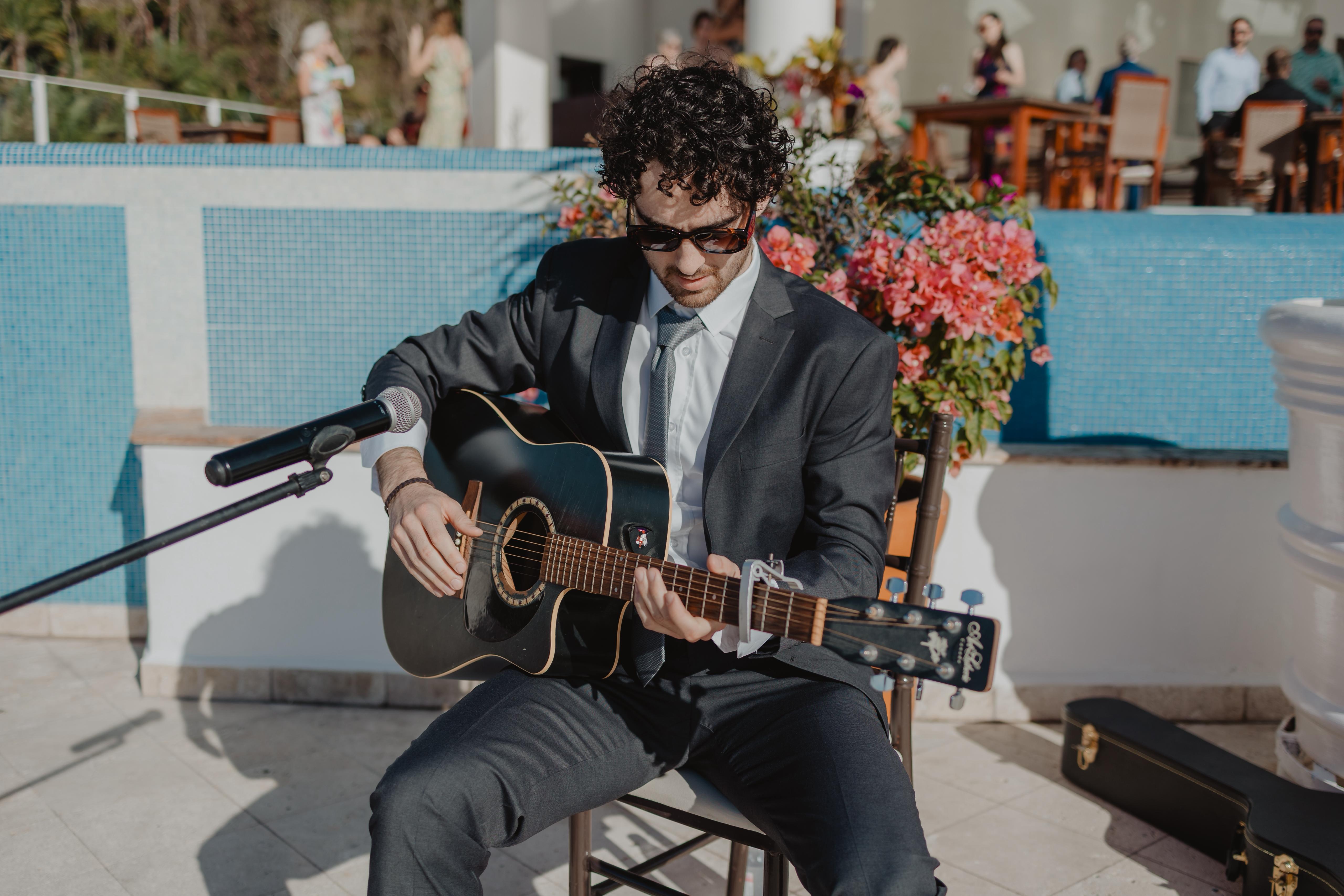 Ethan Luce playing acoustic guitar at a wedding